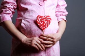 Portrait of pregnant woman with big lollipop