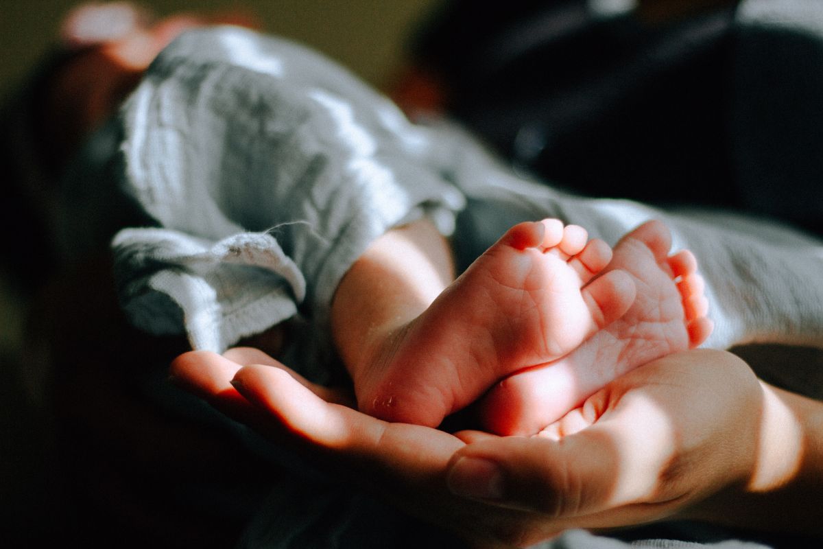 Stópki dziecka na dłoni matki.